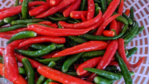 Close-up of stacked fresh raw red and green peppers on basket  