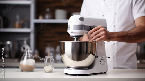 Male hand pushing button on white electric food mixer