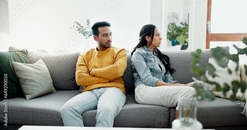 Conflict, fight and couple angry on a couch together duo to infertility, argument and toxic relationship in a home. Unhappy, divorce and man has problem with woman in a living room sofa for cheating photo