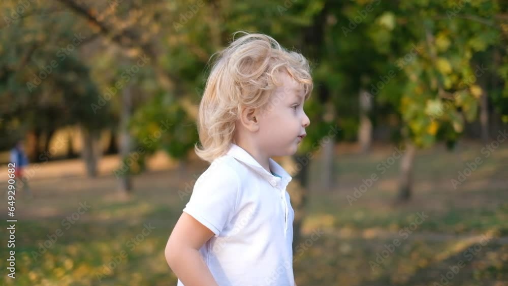 The kid walks in the park in the fall and talks. A walk with a child in warm autumn. Child education. The kid walks in the park in the fall and talks. A walk with a child in warm autumn. Child education.