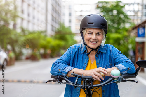 Portrait of senior woman wearing helmet while riding bicycle in the city 