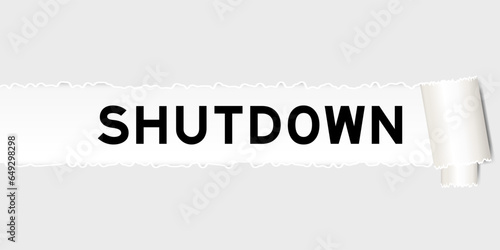 Ripped gray paper background that have word shutdown under torn part