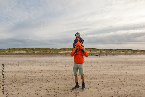 Papa und Sohn spielen im Sturm am Strand in Skagen, Dänemark