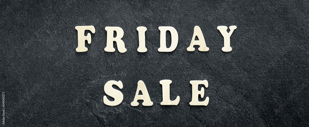 Fototapeta premium Wooden text Black friday sale on black textured background, top view.