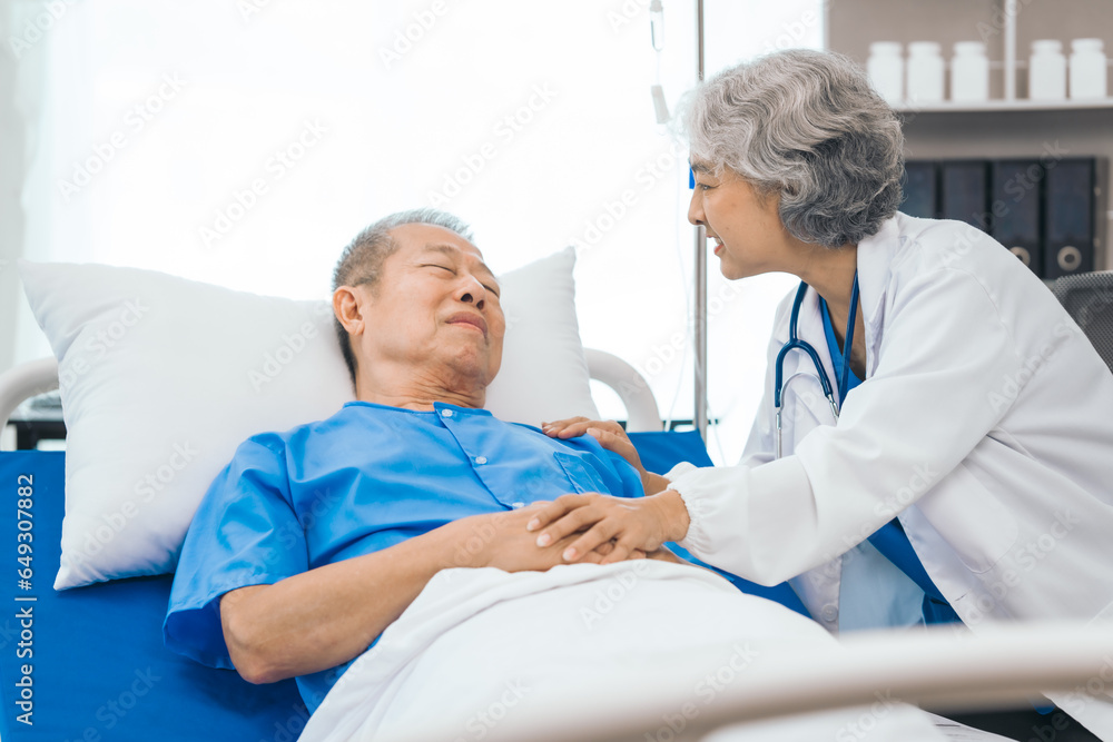 Fototapeta premium Senior elderly male patient and asian people mature woman doctor, showcasing importance of healthcare expertise and patient support. caring senior doctor assisting elderly patient in hospital bed