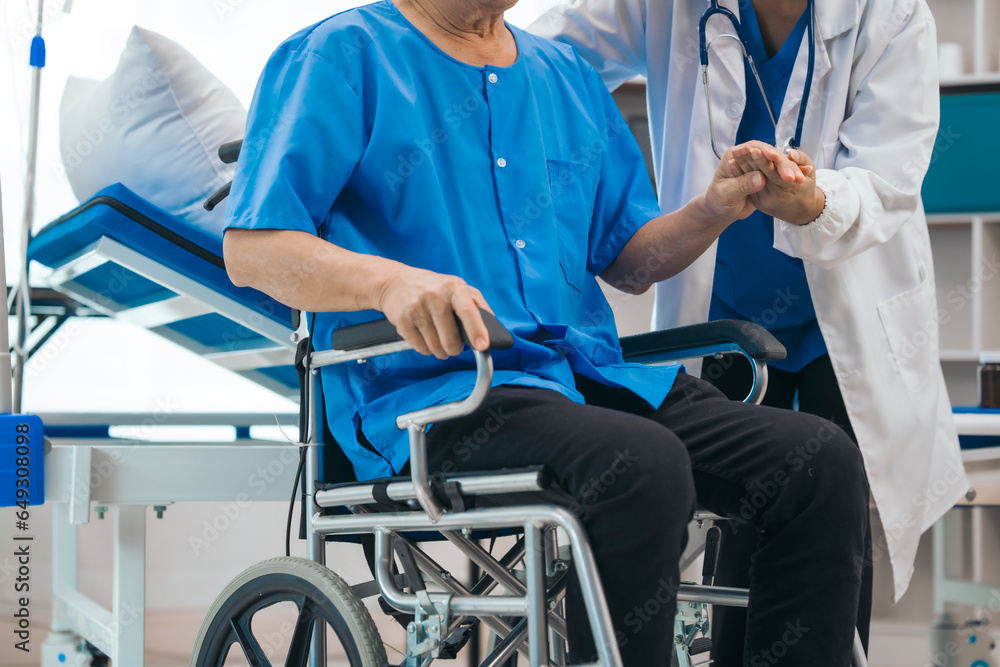 Asian people mature woman doctor giving male elderly patient through indoor physical therapy in a healthcare wheelchair, emphasizing hands-on support and recovery. expert physical therapy Asian people mature woman doctor giving male elderly patient through indoor physical therapy in a healthcare wheelchair, emphasizing hands-on support and recovery. expert physical therapy