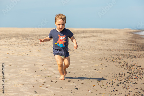 Junge spielt ausgelassen am Strand, Grenen bei Skagen, Dänemark photo