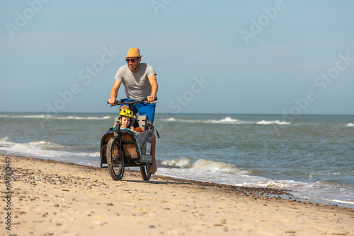 Papa und Kind haben Spaß mit dem Lastenrad am Strand,Skagen,Dänemark photo