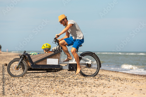 Papa und Kind haben Spaß mit dem Lastenrad am Strand,Skagen,Dänemark