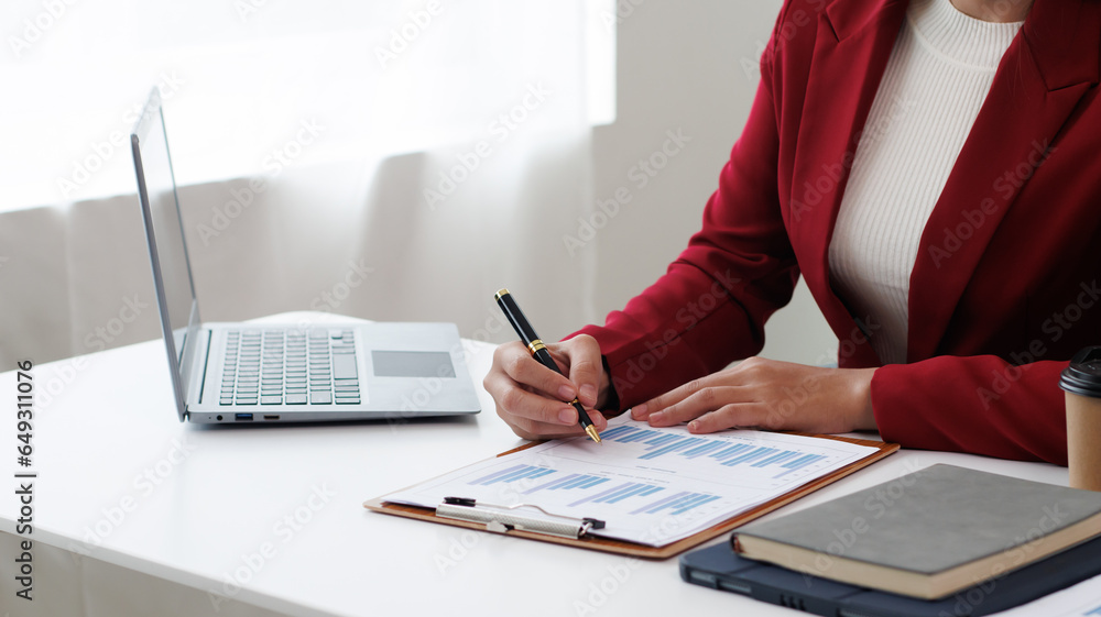 Asian businesswoman talking on the phone and smiling at home and working at table, laptop and coffee cup Asian businesswoman talking on the phone and smiling at home and working at table, laptop and coffee cup