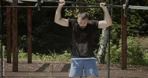 Young man doing mixed exercises for strength and explosiveness, outdoor scene, slow-motion photo