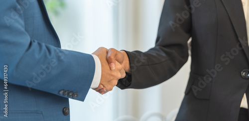 handshake after partnership meeting success business contract deal. Handshaking for good deal contract agreement partner sign contract paper trust.