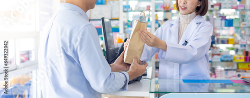 asian thai engineer construction worker customer buy Medication and pharmacist give recycle paper bag at Pharmacy medical shop and drugstore medication. Pharma Store Health Care Products photo