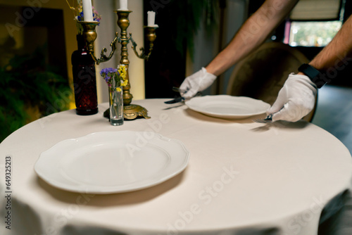 A close-up of a beautifully reserved table at an expensive Italian restaurant being beautifully set up by waiters