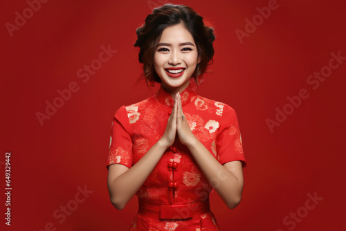 Happy Chinese New Year , Asian woman wearing traditional cheongsam qipao dress on red background photo