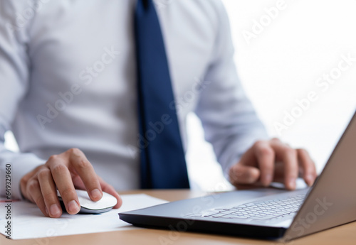 Close-up of businessman using laptop computer in office