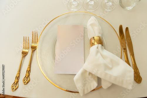 A clean plate, napkin and cutlery on a white table waiting for a delicious treat is the perfect backdrop for a joyful, memorable festive the wedding gala lunch dinner Devices made of expensive silver