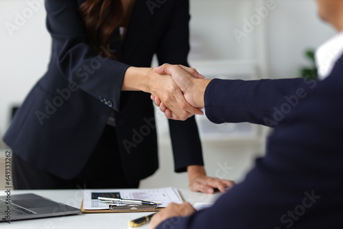 Business partners and colleagues shaking hands at work cooperation. Job applicant shaking hands with executives in office room at job interview.