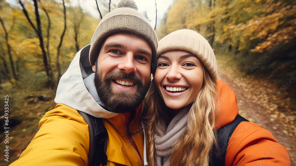 stockphotography, copy space, Attractive couple taking a selfie in a forest in autumn. Outdoors activity. Young couple walking outdoors, exploring nature. Autumn walk.