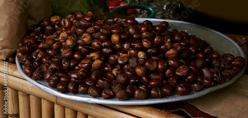 Roasted chestnuts display on the street by vendors in a winter market photo