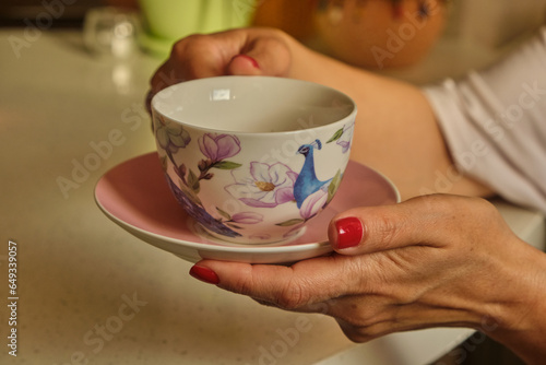 Woman pouring hot coffee in cup in the morning from pot. Housewife at home making fresh ground coffee in kitchen for breakfast, before going to work