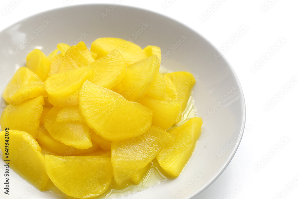 Sweet and tart slices of yellow pickled daikon, known as takuan in Japan and danmuji in Korea. Sweet and tart slices of yellow pickled daikon, known as takuan in Japan and danmuji in Korea.
