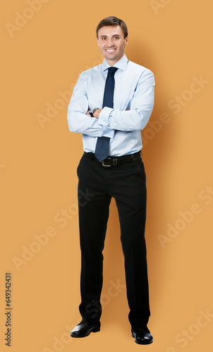Full body, growth length portrait image - business man in confident cloth, necktie tie, folded hands, isolated brown beige background. Businessman, bank manager, real estate sales agent