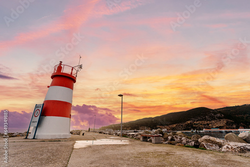 White red lighthouse on the shore in Sesimbra, Portugal.