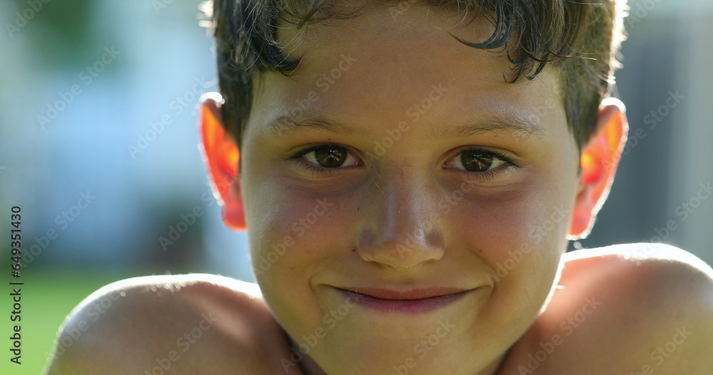 Handsome young boy child face smiling feeling happy and joy in outdoor sunlight. Kid portrait real life smile Handsome young boy child face smiling feeling happy and joy in outdoor sunlight. Kid portrait real life smile