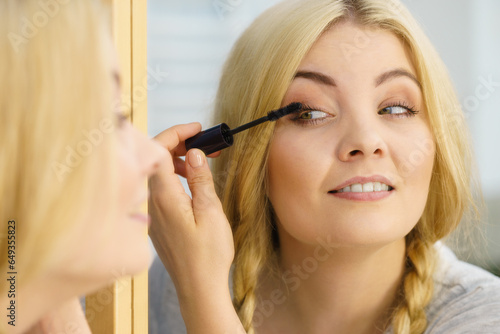 Woman using mascara on her eyelashes