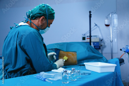 Surgical doctor cleaning with anti septic in back of patient preparing for epidural anesthesia for reducing pain before surgery in operation room at hospital. medical concept. photo