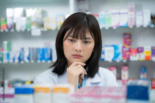 Young asian female pharmacist working at pharmacy store. Pharmacy, Medical, Healthcare, Lifestyle and Science concept.