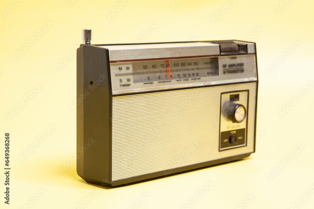 Obraz premium Vintage transistor radio, on yellow background.