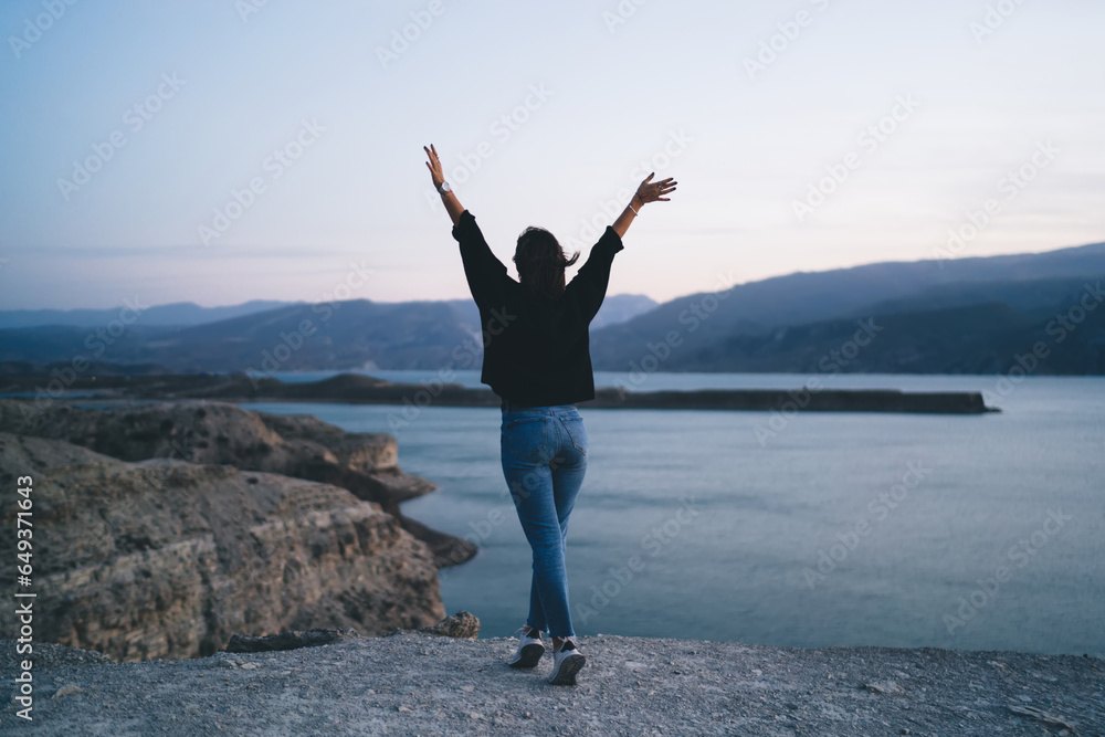 Carefree faceless woman standing on tiptoes and enjoying freedom on seashore Carefree faceless woman standing on tiptoes and enjoying freedom on seashore