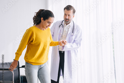 Woman leg injury physical therapy doctor help support try to walk and she very happy after healing and recovery