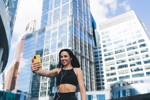 Smiling sporty woman with smartphone taking selfie © BullRun