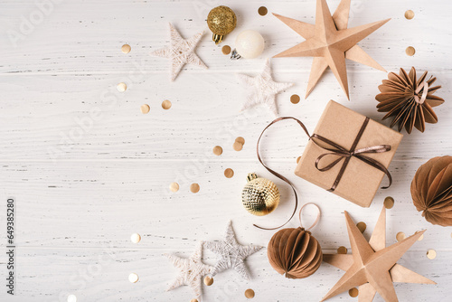 Festive Christmas background with gift box and Christmas decorations on white wooden table. Top view. Copy space for text.