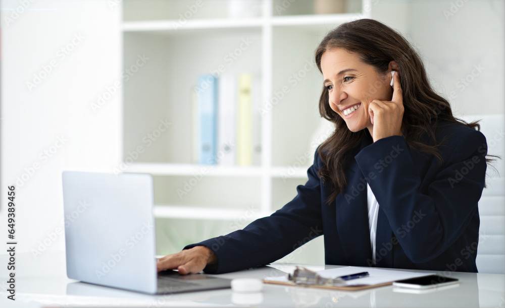 Positive mature woman entrepreneur get video call at office Positive mature woman entrepreneur get video call at office