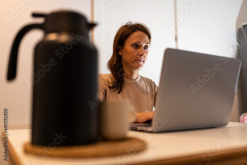 40 year old middle aged woman working with laptop at night