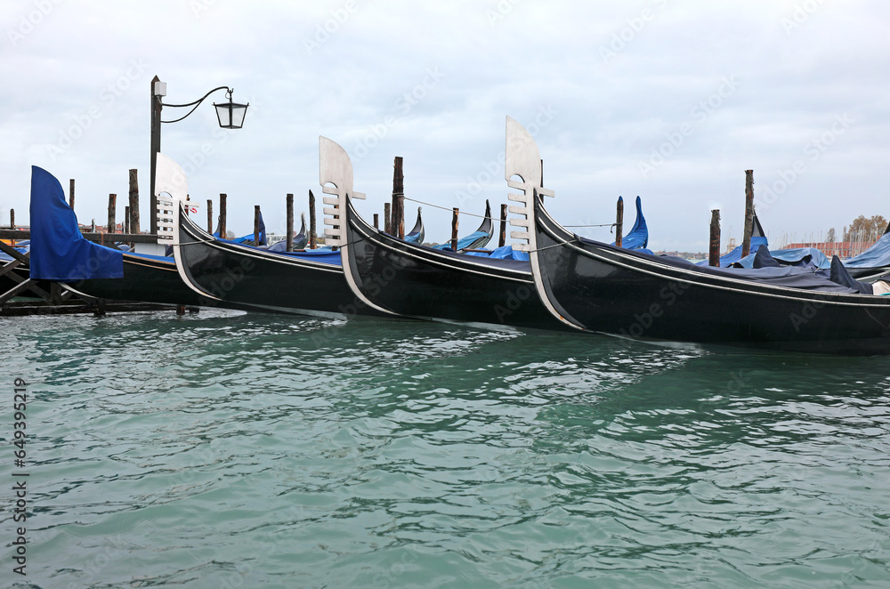 gondolas moored in the Venetian lagoon in Venice with no tourists