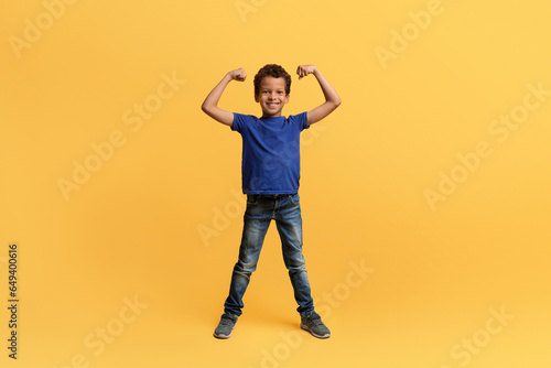 Strong athletic african american school aged boy showing his biceps photo
