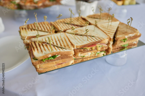 Sandwich with salami sausage and cucumber on marble background.