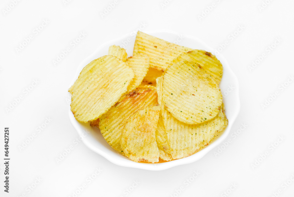 Yellow pieces of fried potatoes in a plate. Salted chips on a white background.