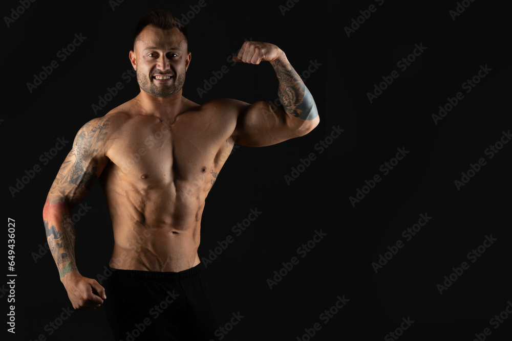 Bodybuilder, strong athletic man. Fitness model, muscular and torso with abs. Isolated on a black background with copy space.