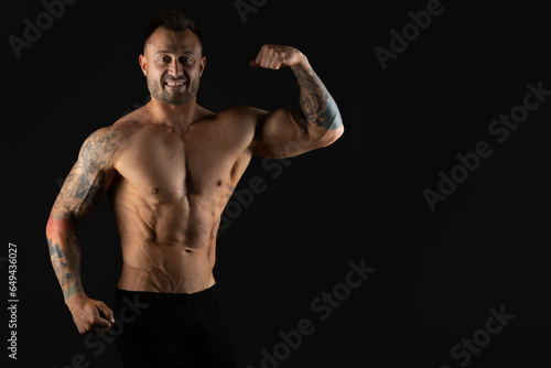 Bodybuilder, strong athletic man. Fitness model, muscular and torso with abs. Isolated on a black background with copy space.