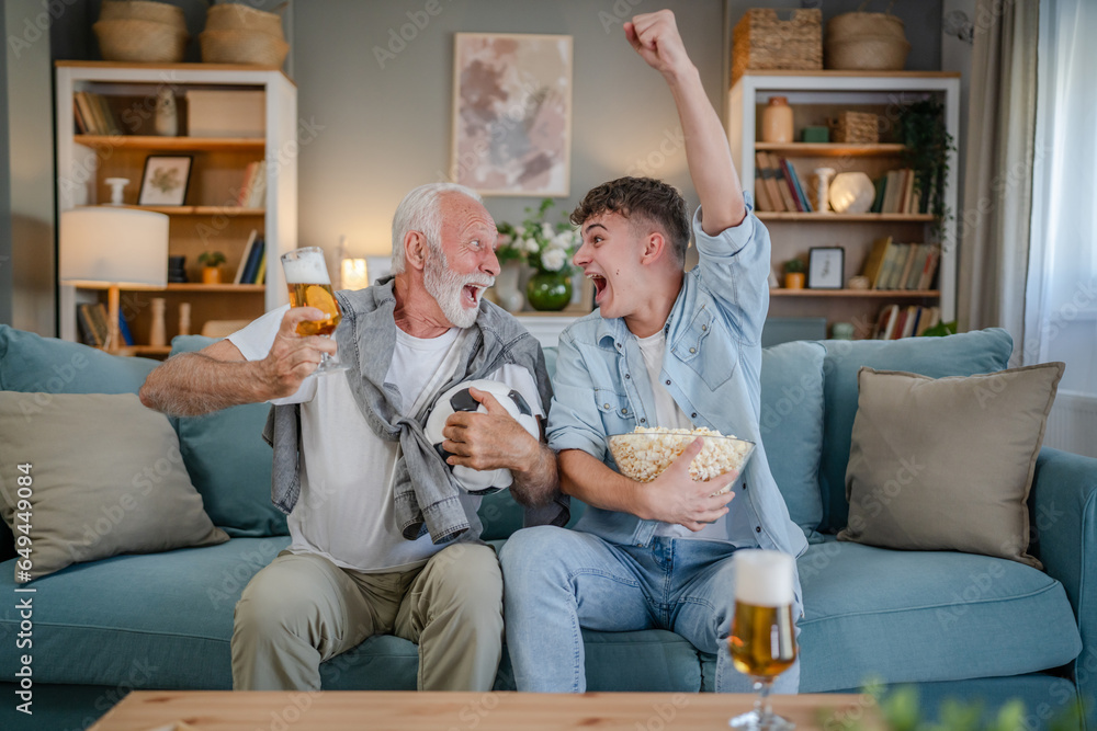 teenager and his grandfather senior man watch football game at home teenager and his grandfather senior man watch football game at home