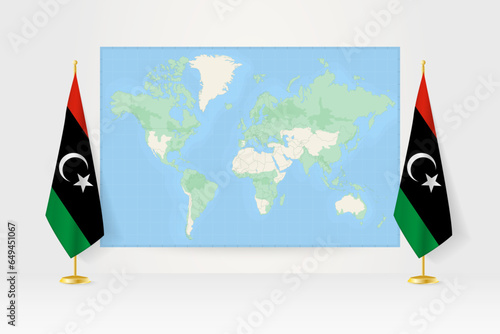 World Map between two hanging flags of Libya flag stand.