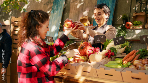 Fotografía Vegetarian client choosing colorful apples and products, looking at organic produce on farmers market stall