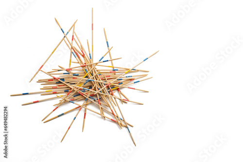 Mikado game on white, wooden pick-up sticks should be taken without moving the others, metaphor in business to solve one problem after another without endangering the whole, copy space