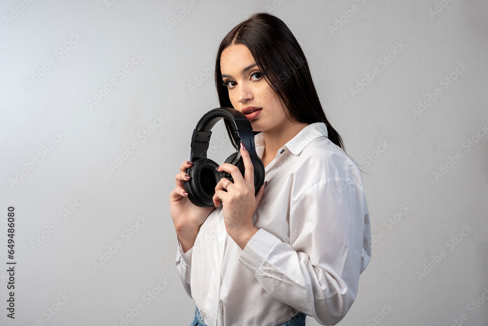 latin young woman with headphones very happy gesturing cheerful wearing white shirt and white background latin young woman with headphones very happy gesturing cheerful wearing white shirt and white background